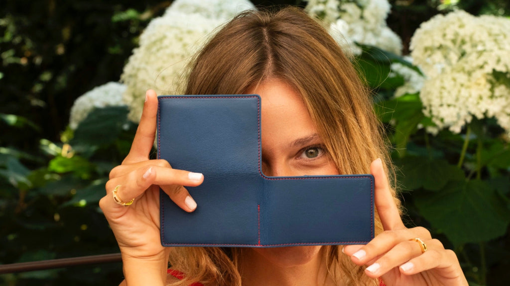 Porte-cartes artisanal Le10Colonne en cuir bleu et coutures rouges présenté en situation lifestyle